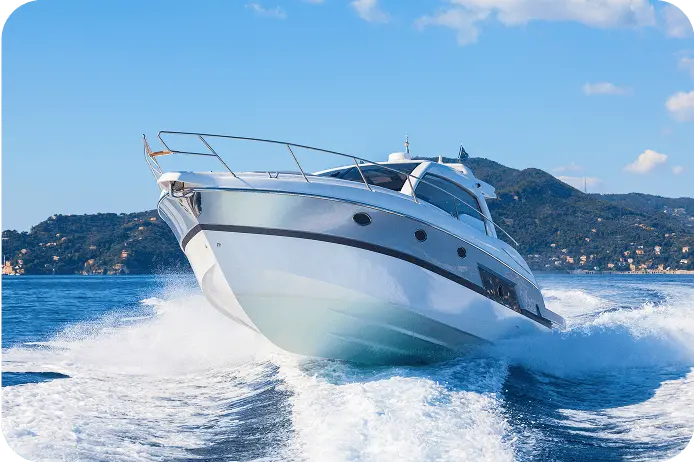 青い海の上を高速で走行する白いクルーザーが正面から写っている